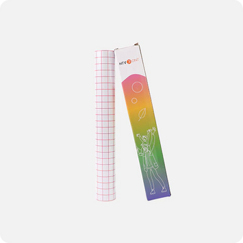 Roll of grid paper next to a colorful packaging box on a white background