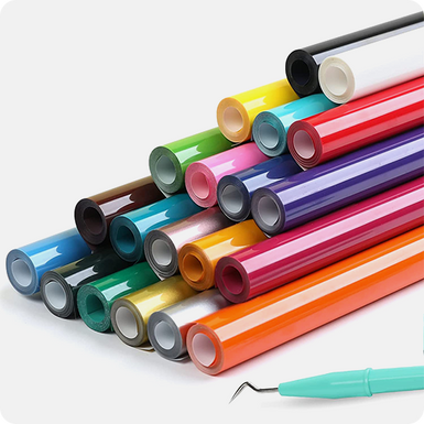 Assorted colorful rolls of vinyl with a tool on a white background