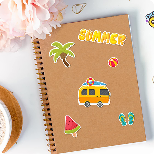 Notebook with summer-themed stickers on a white surface