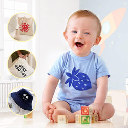 Baby wearing a blue shirt with a blue strawberry design, surrounded by baby products.